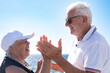 © luciano - Smiling senior pensioner couple hands in hands face the sea enjoying freedom and vacation, Background of blue ocean and sky, a perfect scene of love, companionship and happiness in retirement