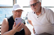 © luciano - Elderly pensioner couple joyfully sharing a moment looking at smartphone together. Their expressions convey happiness, friendship, positivity and companionship, staying connected in the digital age