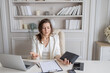© night87 - A business lady is sitting at a desk in a bright office. The plot of a tense situation, problems with work, business, finances.She looks worried and nervous.