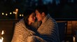 Young asian couple sharing an intimate moment wrapped in a blanket by firelight