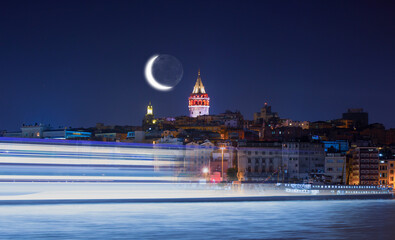 Poster - Galata Tower, Galata Bridge, Karakoy district and Golden Horn with motion speed light of passing ferry in the foreground at night istanbul - Turkey  