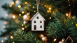 © BlockBrushstrokes - Vertical atmospheric shot of Christmas decor including a house figure on a decorated Christmas tree with lights and balls. Real estate and housing buying.