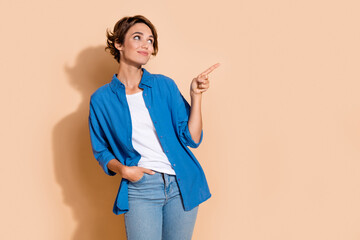 Poster - Photo of young business woman wear blue shirt pointing finger empty space cryptocurrency startup isolated on beige color background