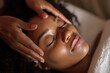 © Smaev - A black woman receives a soothing head massage at a spa salon