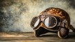 © Artittaya - A vintage leather aviator helmet and aged goggles resting on a weathered wooden table in soft natural light