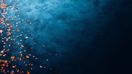 Leinwandbilder - Close-up of bright orange autumn leaves scattered on a dark blue surface captures the essence of fall with a bold seasonal contrast and inviting copy space