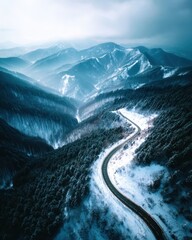 Wall Mural - A mountain range with a winding road that is covered in snow
