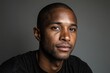 © Darcraft - Professional portrait of a man with short hair, wearing a dark shirt, gazing confidently at the camera, with a neutral expression and soft lighting enhancing facial features