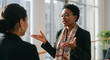 © Andres Mejia - Businesswoman gesturing while explaining something to colleague in office