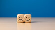 © abu - Wooden Cubes Depicting Happy and Sad Faces on White Surface Against Blue Backdrop