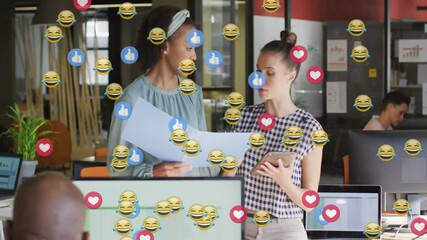Poster - two women discussing business documents in open office, floating reaction icons indicating feedback