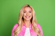 © deagreez - Portrait of a cheerful blonde woman in a pink shirt standing against a green background expressing joy and positivity