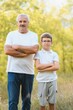 © Serhii - Portrait of happy grandfather and grandson in autumn park