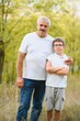 © Serhii - Portrait of happy grandfather and grandson in autumn park