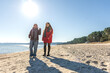 © puhimec - Two women walking on the seashore. Two friends enjoying and spending time together.