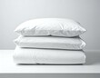 © fara - Stack of clean white pillows and duvet cover on a white surface. Ideal for bedding, home, and sleep-related concepts.
