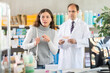 © JackF - Adult man pharmacist offering box of pills to young woman buyer in pharmacy