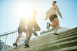 © MollerFinest/peopleimages.com - Fitness, group and running in city for exercise, body wellness or friends training with coach in low angle. Team, cardio and people workout outdoor on steps for health, sport and race with energy