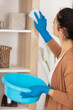 © auremar - woman cleaning dust from bookshelf