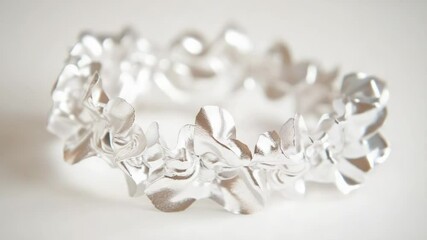 Poster - Close-up shot of a silver bracelet on a white background, ideal for jewelry or accessory promotions