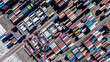 © Monet_P - Aerial top view of organized stacks of colorful shipping containers at a busy cargo yard. The image reflects the logistics efficiency and volume of global trade through maritime transport.