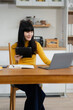 © NINENII - Lifestyle people, using computer working online, doing searching, sitting in the kitchen. Happy woman, entrepreneur, small business owner working online at home office.