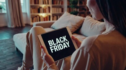 Poster - Comfortable woman relaxing on living room sofa during dark evening, browsing black friday digital advertisement on tablet screen while enjoying quiet leisure moment