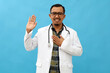 © ArvStd - Adult asian man wearing doctor suit and stethoscope swearing with hand on chest and open palm, making a loyalty promise oath