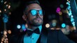 ©  Shomixer - A fashionable man in sunglasses poses confidently against a backdrop of colorful lights at night, conveying modern elegance and self-assured style.