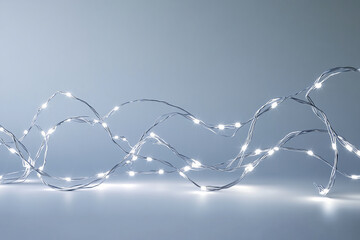Poster - Silver wire string lights on gray background, creating a festive, elegant mood, ideal for holiday or celebration designs, free space for text