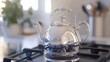 © M - Polished silver tea kettle sits on a kitchen stove.