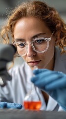 Poster - in a contemporary laboratory, a focused young woman with curly hair and glasses studies a sample und