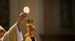 © Lerivan - The priest elevates the host and chalice during the Eucharist, a central Catholic sacrament.