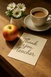 © yollieee - A neatly arranged scene on a wooden table features a red apple, a thank you card with the words 'Thank you teacher,' a white vase holding white daisies