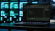 © DC Studio - Close up of code running on laptop screen in data center used for managing gear energy consumption. Focus on notebook used by software developer in blurry background in server farm, camera A