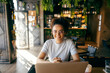 © Dusan Petkovic - Portrait of female college student sitting in coffee shop with laptop and smiling at camera.