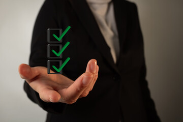 Poster - hand of a businesswoman holding three checkmarks in a 3d box