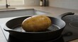 © vector Art - A Single Baked Potato in a Cast Iron Skillet on a Modern Kitchen Countertop