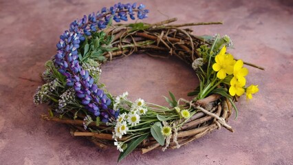 Wall Mural - a wreath made of flowers and twigs with a blue flower in the center. the flowers are yellow and purp