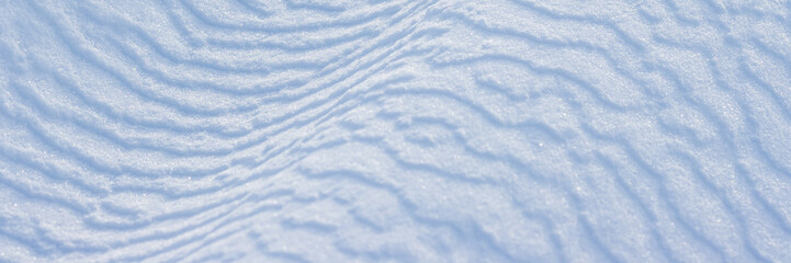 Wall Mural - beautiful winter background with snowy ground. natural snow texture. wind sculpted patterns on snow 