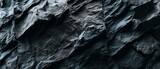 Rough grainy black stone texture background with dark gray sand-like surface, high-resolution seamless backdrop for industrial design, minimalist interior renderings, and premium product mock-ups
