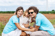© TeTe Song - Happy Caucasian family is relaxing in a windmill field surrounded by nature. They are wearing blue shirts in line with the concept of environmental conservation, volunteer, clean, wind turbine, care