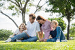 © Nopphon - Happy family parent children having picnic outdoor activity. Enjoy happiness moment summer playing together including father mother son and daughter relaxing in the morning sunrise.