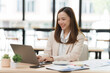© Kritdanai - Smiling Asian Businesswoman Working on Laptop