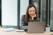 © Kritdanai - Smiling Young Woman Working on Laptop