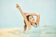 © Dialogue Frame - Energetic Young Woman Stretching on the Beach