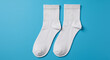 © baasith88 - Pair of clean white socks on a vibrant blue background, simple and minimalist.