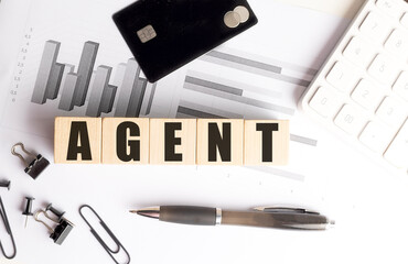 Poster - Wooden blocks with word agent on office desk with charts, credit card, calculator and stationery items