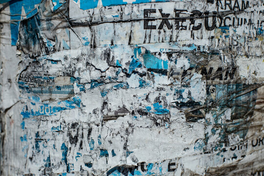 Ripped paper scraps on a poster pole, abstract textured backdrop