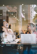 © BullRun - Emotional young female best friends laughing talking to each other on free time break in cafeteria, positive multiracial overjoyed women having fun while discussing plans for online project on leisure